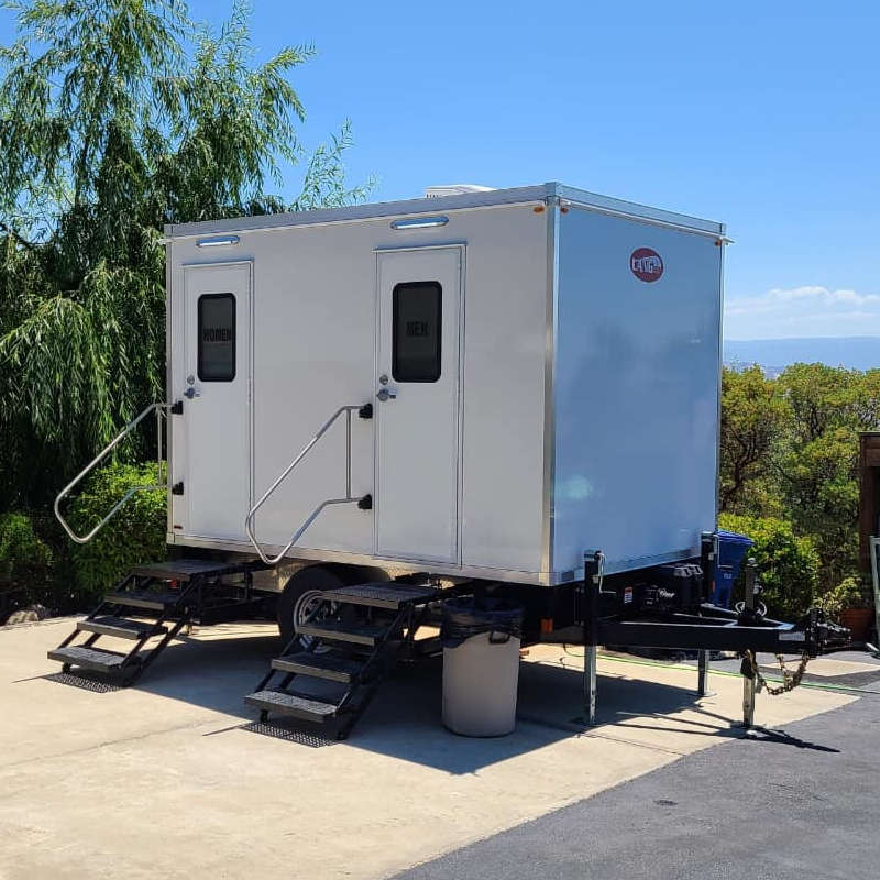Luxury bathroom trailer with steps on a hilltop patio with a distant water view, The Lavatory Los Angeles