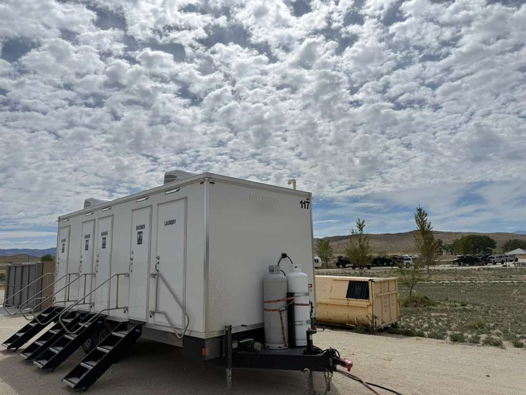 4-station combo trailer with propane tanks at a desert job site under a cloudy sky, The Lavatory Los Angeles