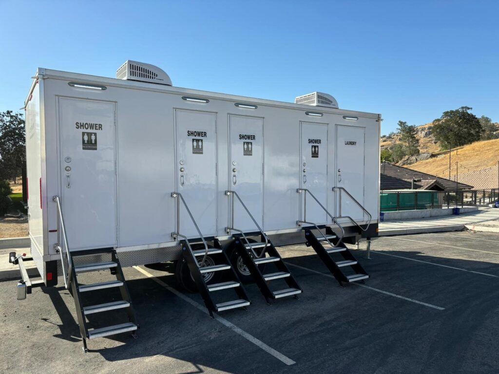 4-station combo trailer with four shower doors, a laundry door and steps at each entry in a parking lot, The Lavatory Los Angeles