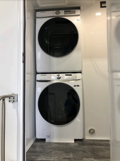 Stacked Samsung washer and dryer inside the laundry room of a 4-station combo trailer, The Lavatory Los Angeles