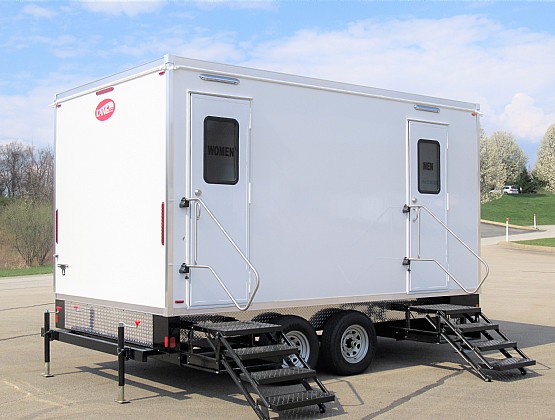 Luxury bathroom trailer with women's and men's doors and fold-down steps on a paved lot, The Lavatory Los Angeles