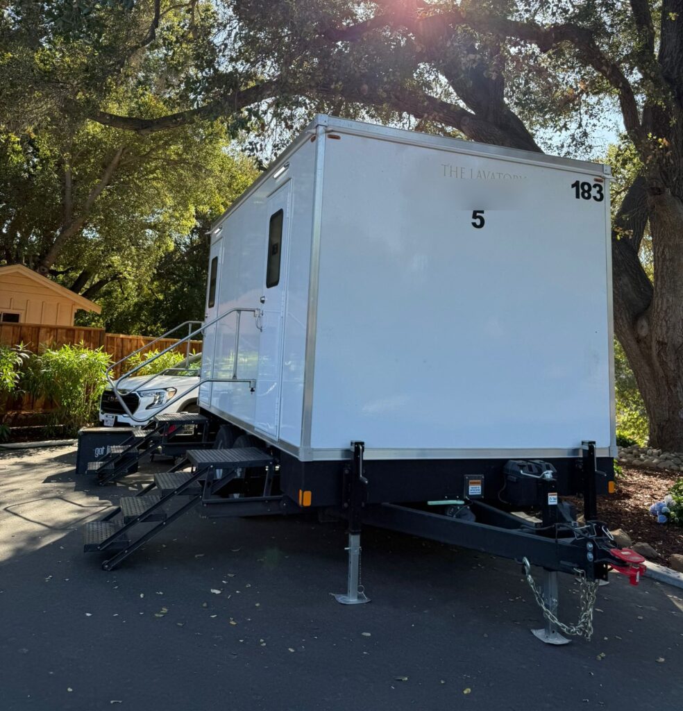 5-station bathroom trailer leveled on a driveway under a large oak tree during a neighborhood power outage, The Lavatory Los Angeles