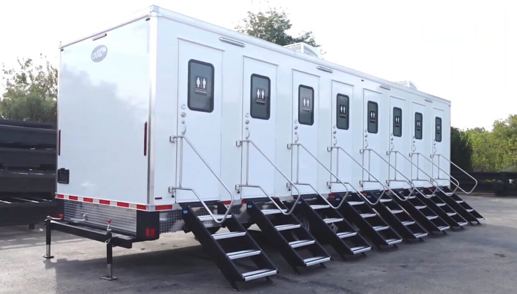 Angled side view of an 8-station private stall deluxe trailer with steps at every door, The Lavatory Los Angeles