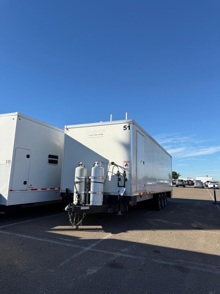 8-station laundry trailer with propane tanks staged at a port lot before shipping, The Lavatory Los Angeles