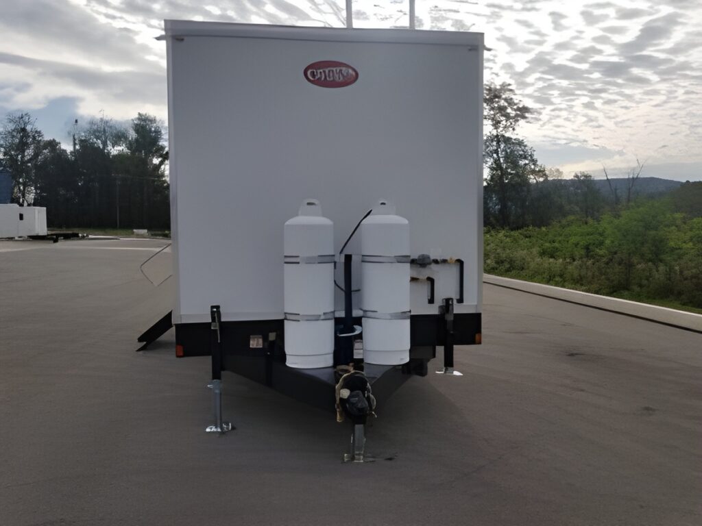 Rear view of a mobile laundry trailer with mounted water tanks on a paved lot, The Lavatory Los Angeles