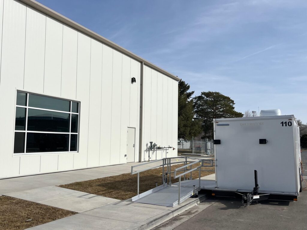 Accessible combo trailer with a ramp down to the sidewalk beside an industrial building on a monthly rental, The Lavatory Los Angeles