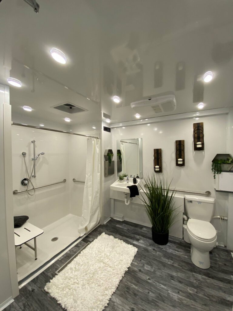 ADA combo trailer interior with roll-in shower, fold-down bench, toilet and grab bars, The Lavatory Los Angeles