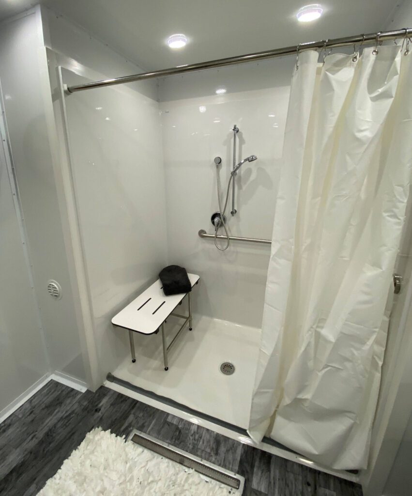 Roll-in shower with fold-down bench, handheld sprayer and curtain in an ADA trailer, The Lavatory Los Angeles