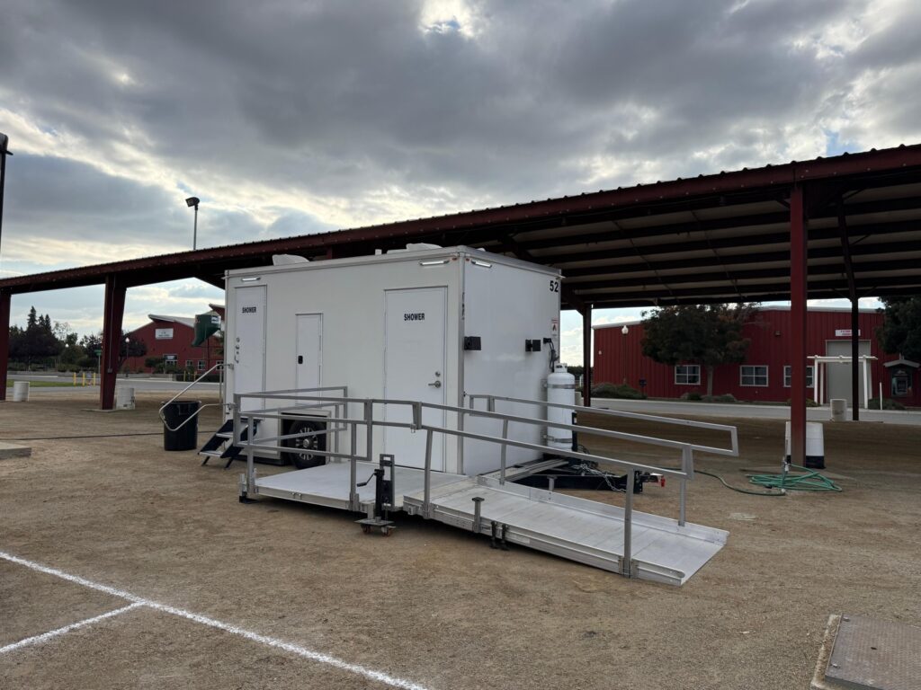 ADA plus 2 shower trailer with ramp and steps under a covered pavilion at a county fairgrounds, The Lavatory Los Angeles