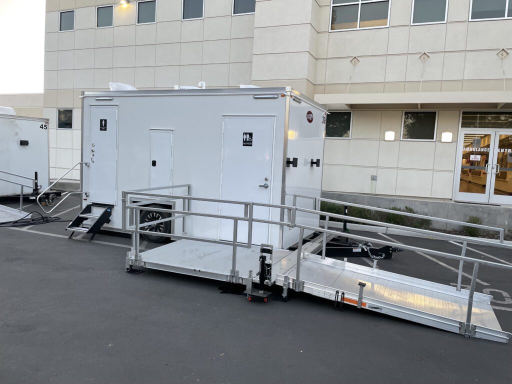 ADA plus 2 bathroom trailer with a ramp platform outside a hospital entrance, The Lavatory Los Angeles
