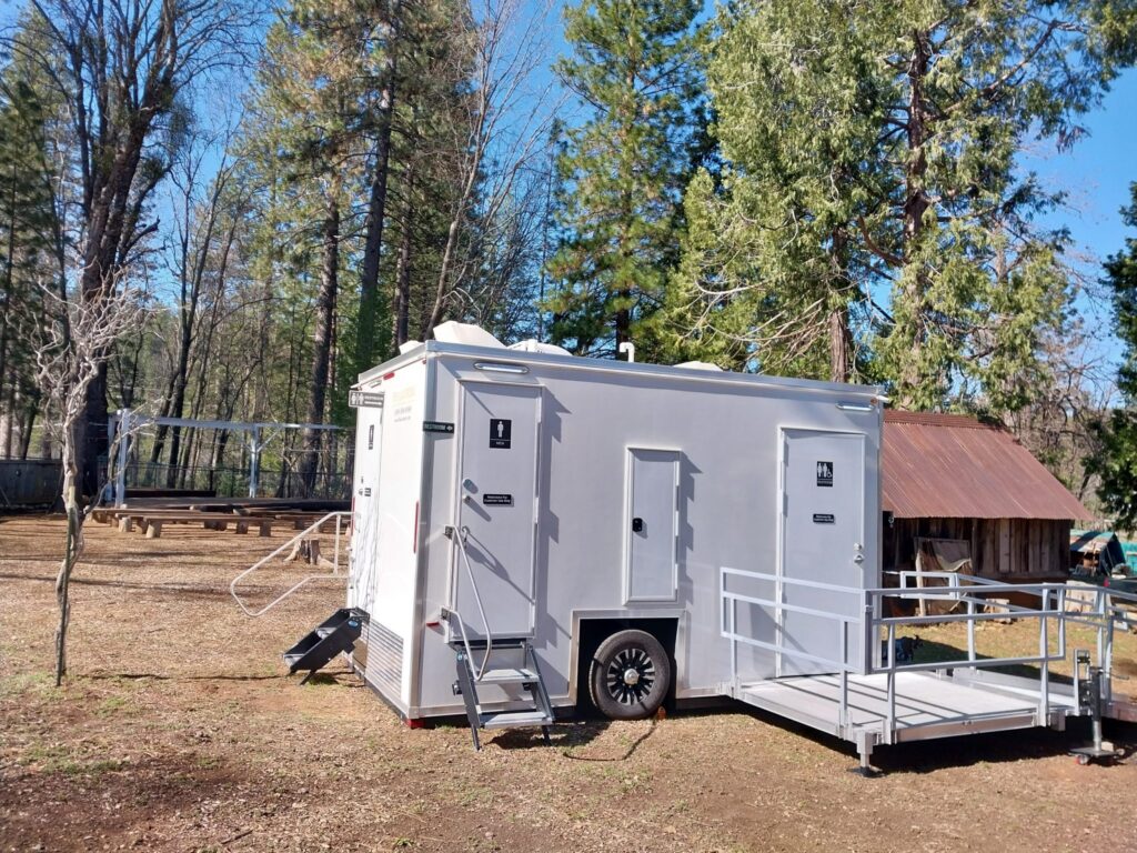 ADA plus 2 bathroom trailer with a ramp platform at a pine forest camp, The Lavatory Los Angeles