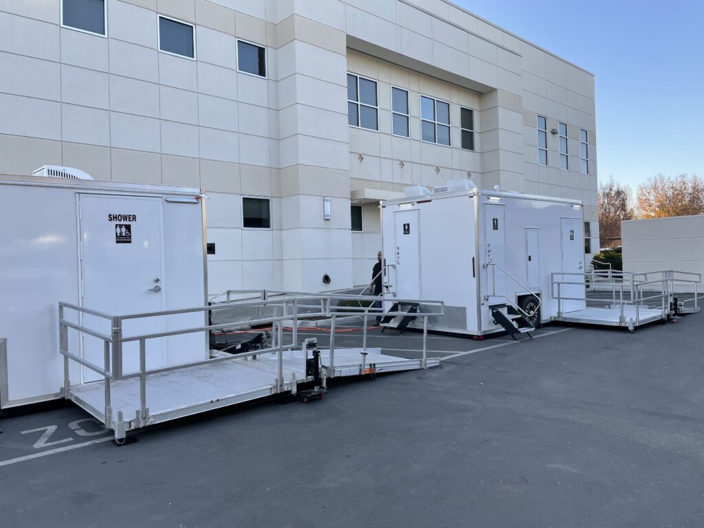 ADA shower and bathroom trailers with ramp platforms beside a medical building, The Lavatory Los Angeles