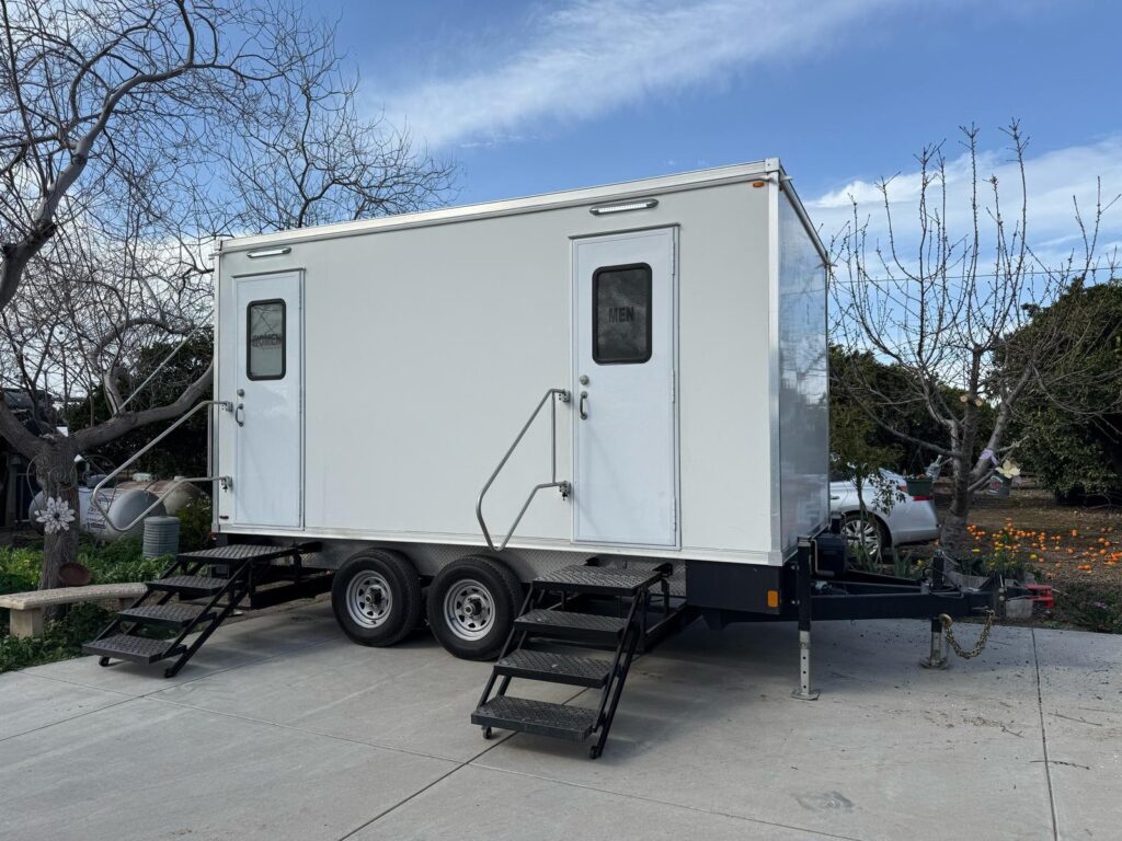 5-station luxury bathroom trailer with two entry doors, fold-down steps and handrails on a paved driveway, The Lavatory Los Angeles