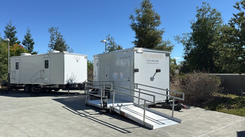ADA plus 2 bathroom trailer with a railed ramp beside a 9-station trailer on an office campus plaza, The Lavatory Los Angeles