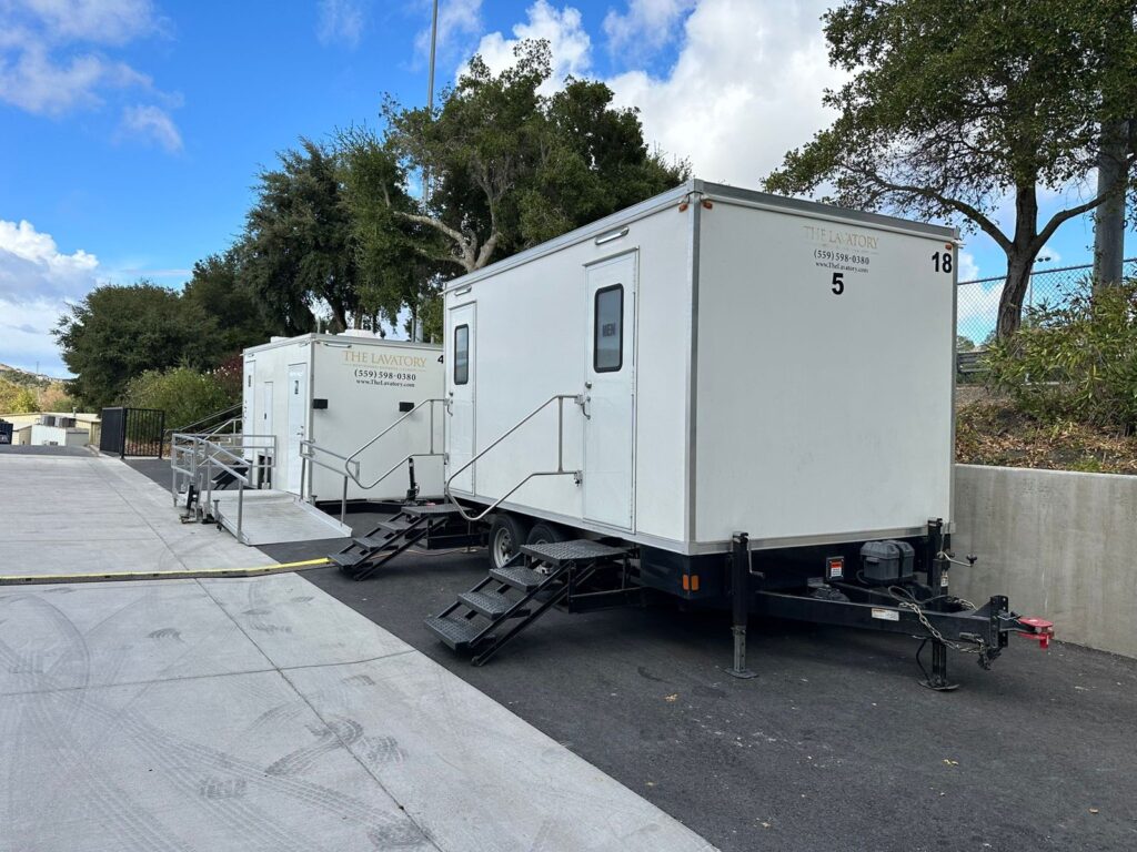 5-station bathroom trailer and an accessible trailer parked along a campus drive for a long-term rental, The Lavatory Los Angeles