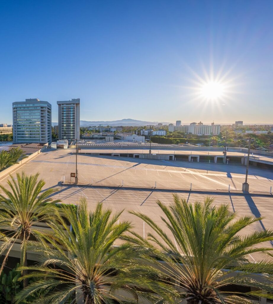 Office towers, a parking deck and palm trees in Anaheim with the Santa Ana Mountains on the skyline, The Lavatory Los Angeles