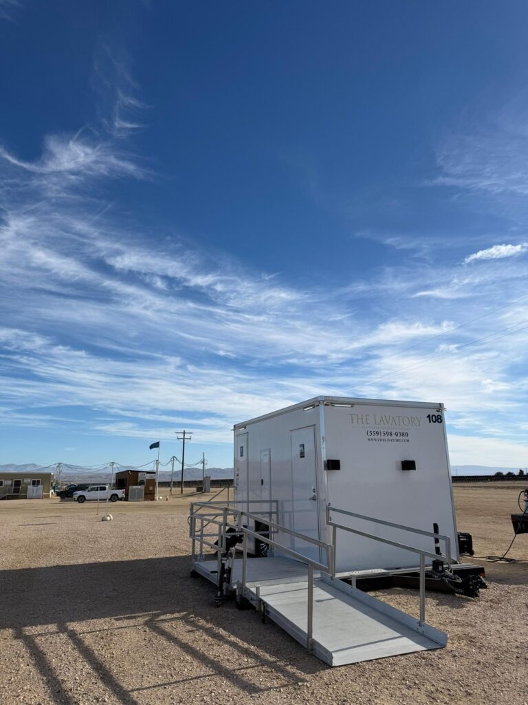 Accessible portable bathroom trailer with a railed ramp on a desert energy job site, The Lavatory Los Angeles