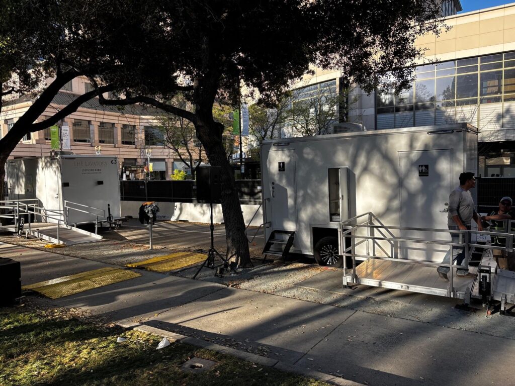 Setup crew assembling the ramp platform on an ADA plus 2 bathroom trailer at a downtown event plaza, The Lavatory Los Angeles
