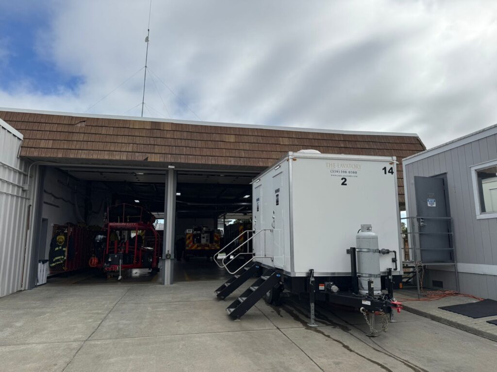 2-station combo trailer parked beside the open apparatus bay of a city fire station, The Lavatory Los Angeles