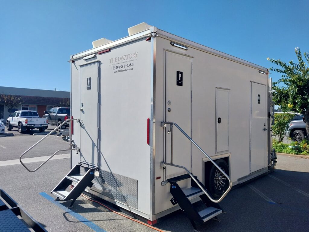 ADA plus 2 bathroom trailer with steps and a men's door in a shopping center parking lot, The Lavatory Los Angeles