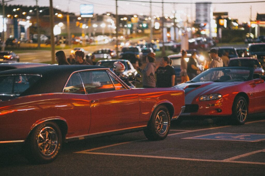 People walking among classic cars at an evening car show, The Lavatory Los Angeles