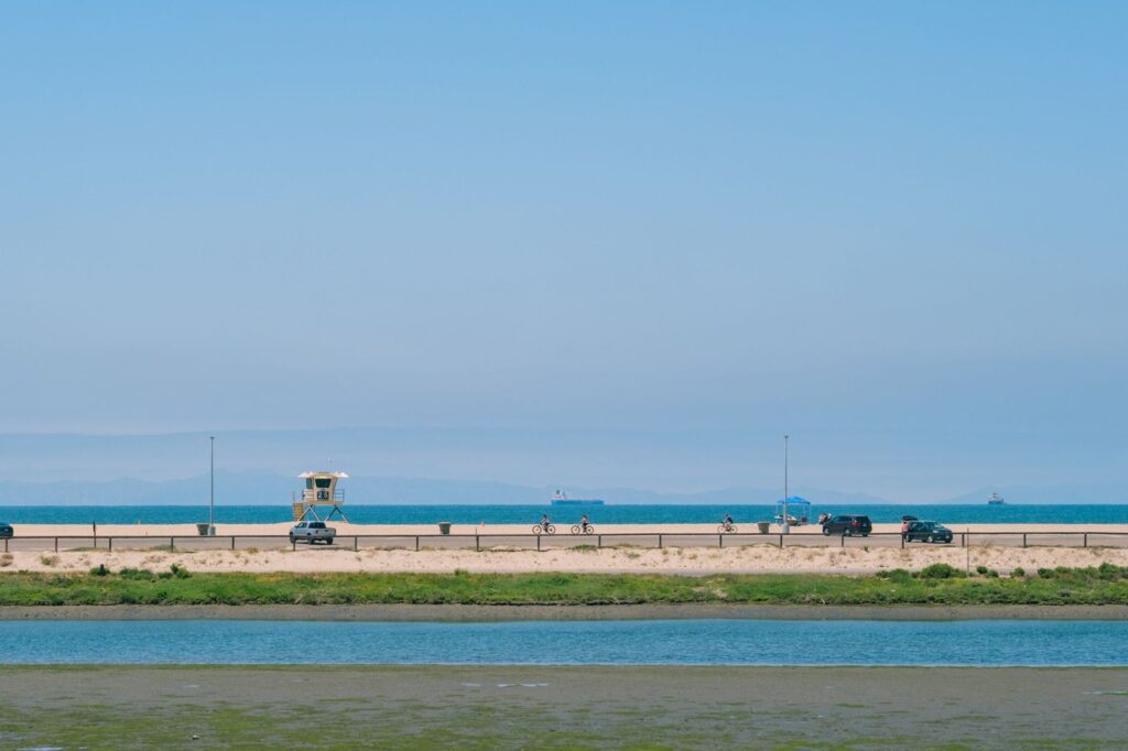 Bolsa Chica wetlands with Pacific Coast Highway, a lifeguard tower and the ocean behind in Huntington Beach, The Lavatory Los Angeles