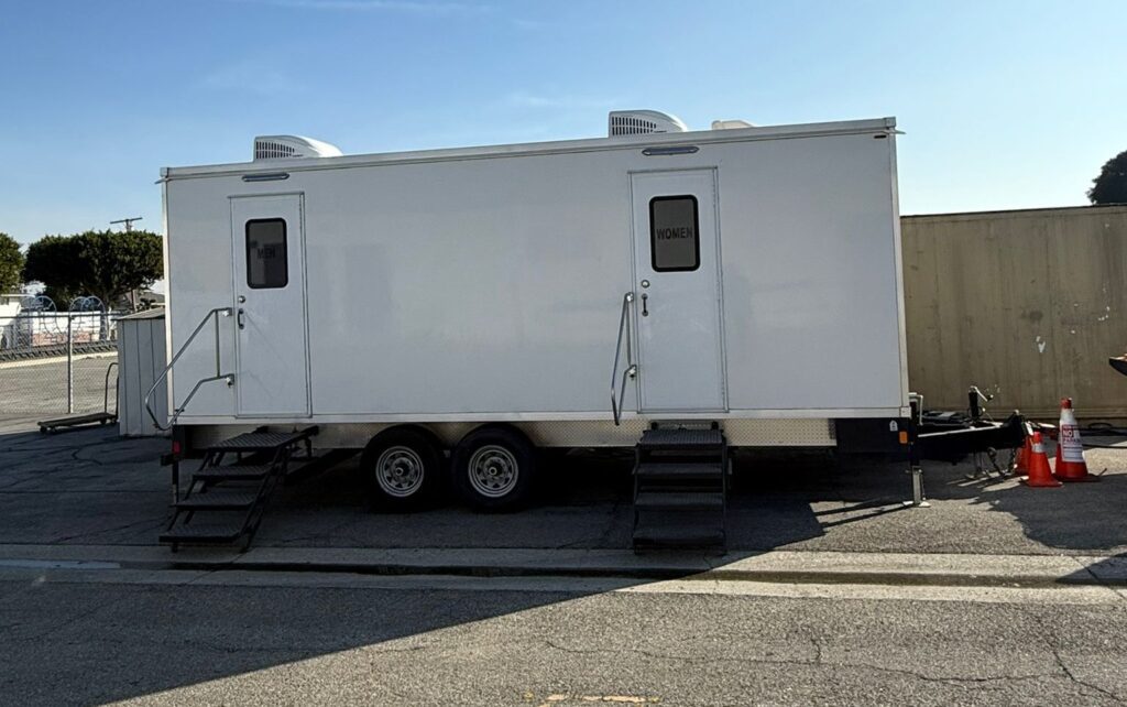 9-station bathroom trailer with two entry steps set up at a school lot in Inglewood, The Lavatory Los Angeles