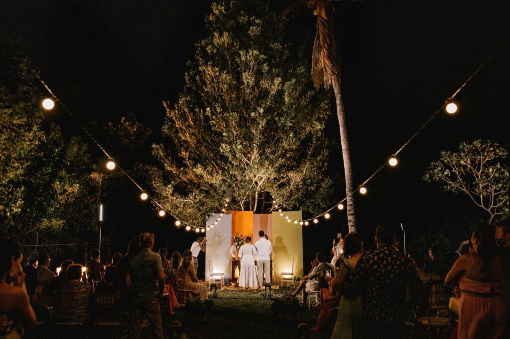 Wedding guests gathered under string lights at a garden ceremony at night, The Lavatory Los Angeles