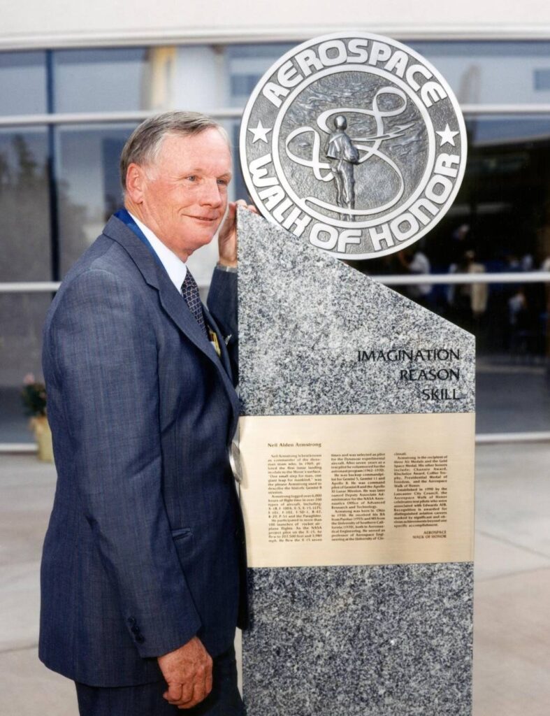 Test pilot standing beside an Aerospace Walk of Honor monument in Lancaster, CA, The Lavatory Los Angeles