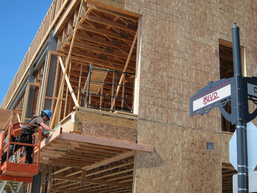 Construction worker in a hard hat on a lift framing a new building on The BLVD in downtown Lancaster, CA, The Lavatory Los Angeles