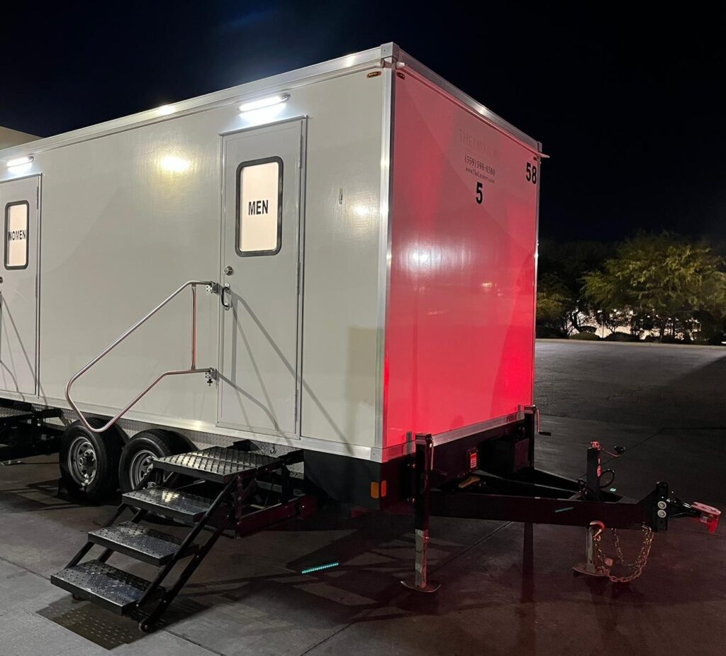 5-station bathroom trailer lit up at night by a loading dock for an overnight shift, The Lavatory Los Angeles