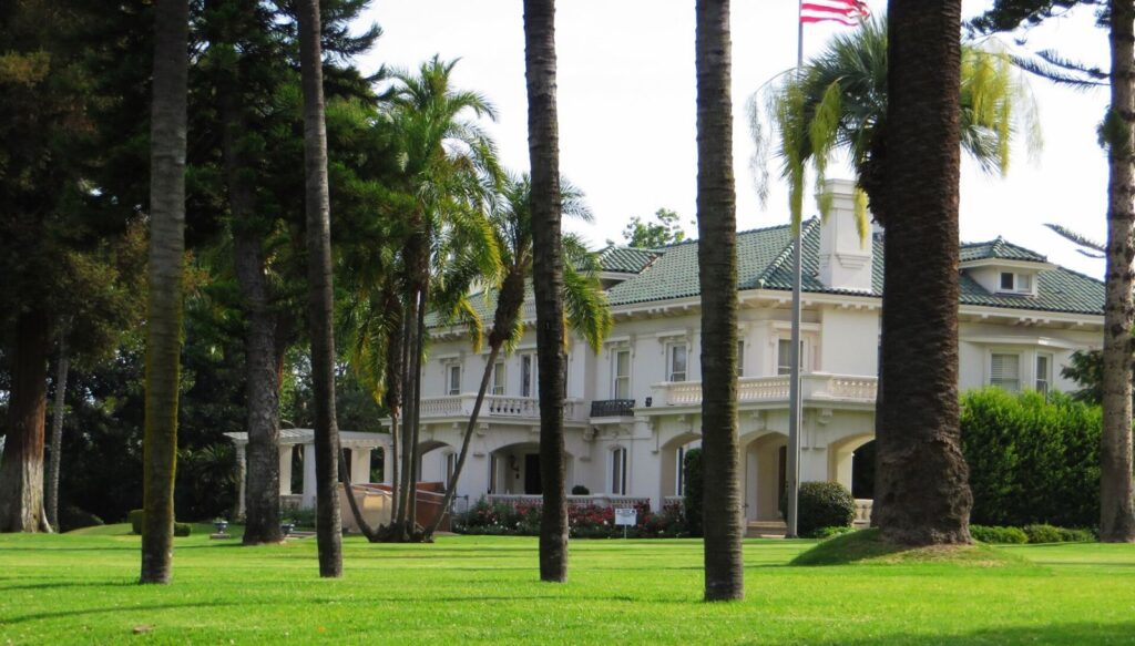 Tournament House, home of the Pasadena Tournament of Roses, behind palm trees and a wide lawn on Orange Grove Boulevard, Pasadena, CA, The Lavatory Los Angeles
