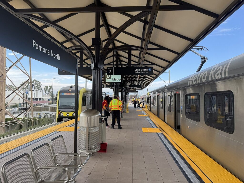 Pomona North station platform on the Metro A Line with a train at the platform and workers in safety vests in Pomona, CA, The Lavatory Los Angeles