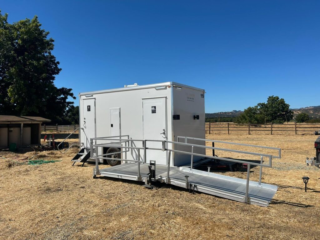ADA plus 2 bathroom trailer with steps and a long railed ramp on a ranch beside a horse fence, The Lavatory Los Angeles