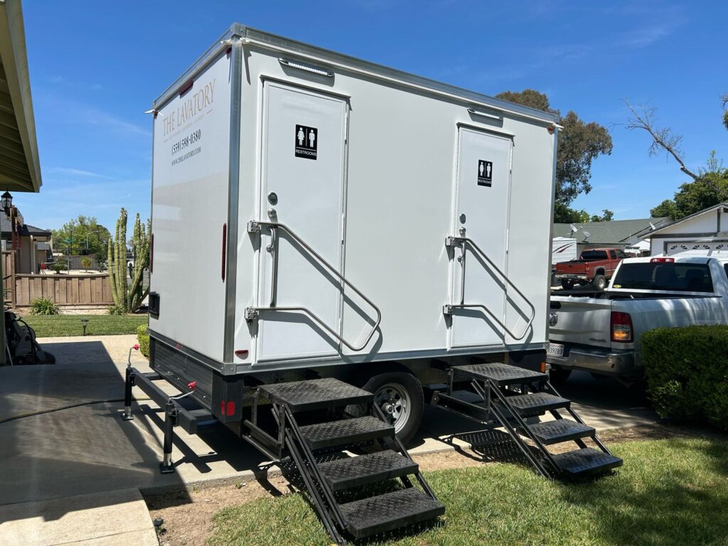 2-station bathroom trailer with two restroom doors and steps parked on a home driveway, The Lavatory Los Angeles