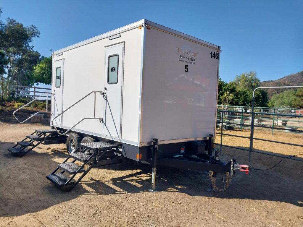 5-station bathroom trailer parked on dirt next to horse corrals with hills behind it, The Lavatory Los Angeles