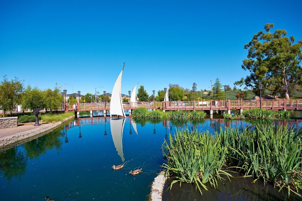 Lake with sail sculptures, ducks and a wooden footbridge in the Bridgeport neighborhood of Valencia, Santa Clarita, CA, The Lavatory Los Angeles