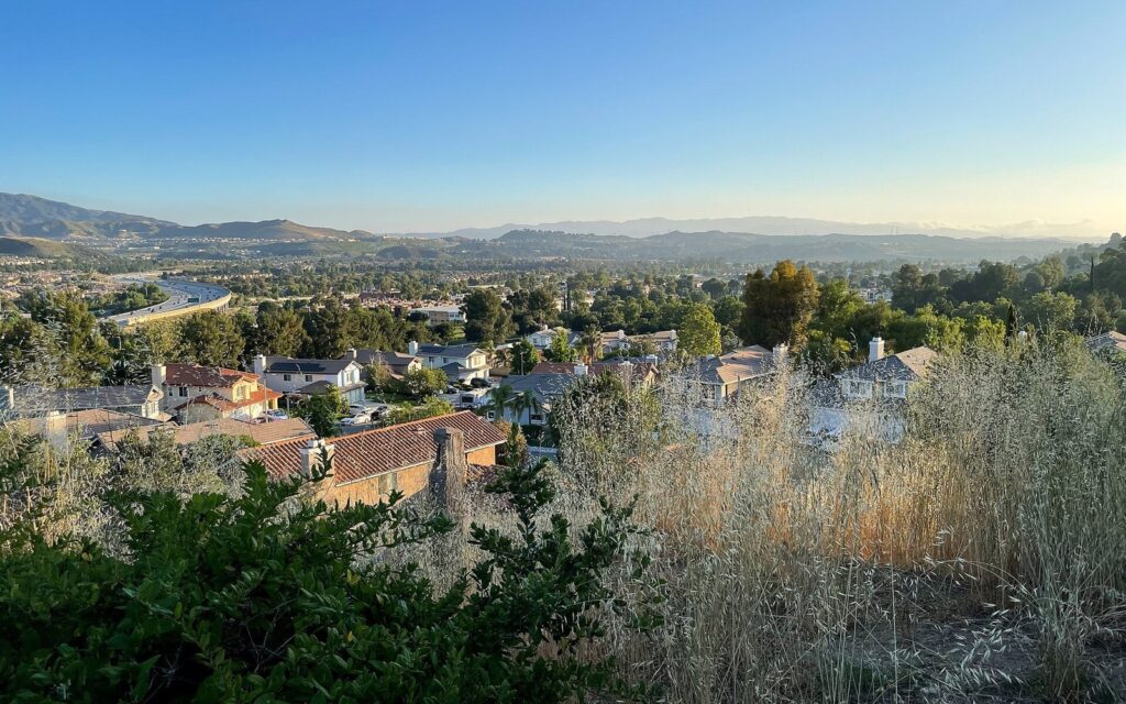 Hillside homes in Canyon Country with a freeway curving through the valley at sunset, Santa Clarita, CA, The Lavatory Los Angeles
