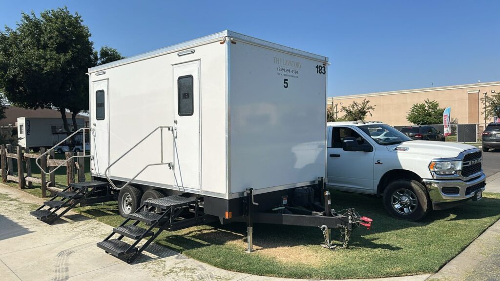 5-station luxury bathroom trailer with two sets of steps on a lawn strip in a business park lot, The Lavatory Los Angeles