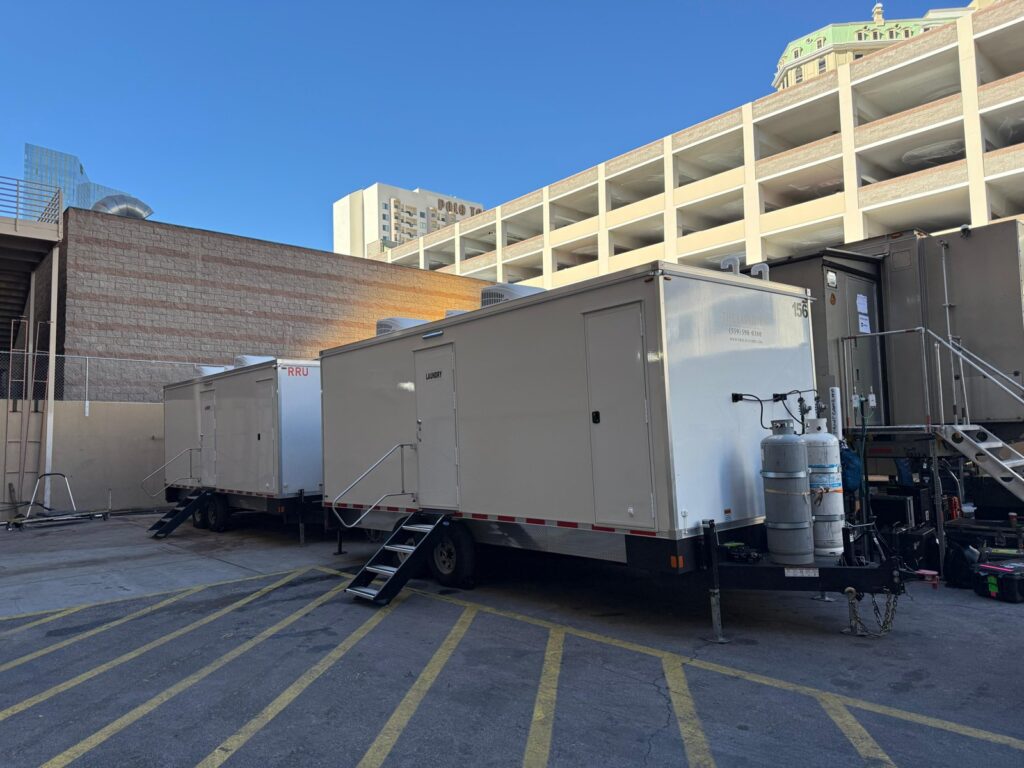 Two mobile laundry trailers parked in a resort parking garage lot with propane tanks and steps, The Lavatory Los Angeles