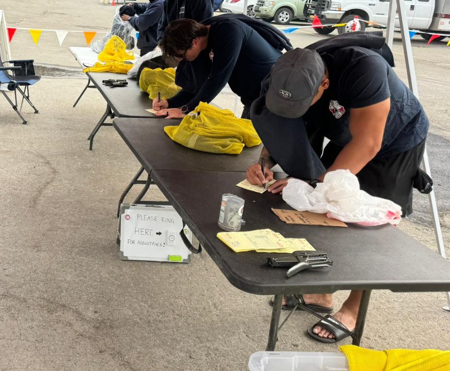 Fire camp workers filling out laundry tags at a mobile laundry drop-off table, The Lavatory Los Angeles